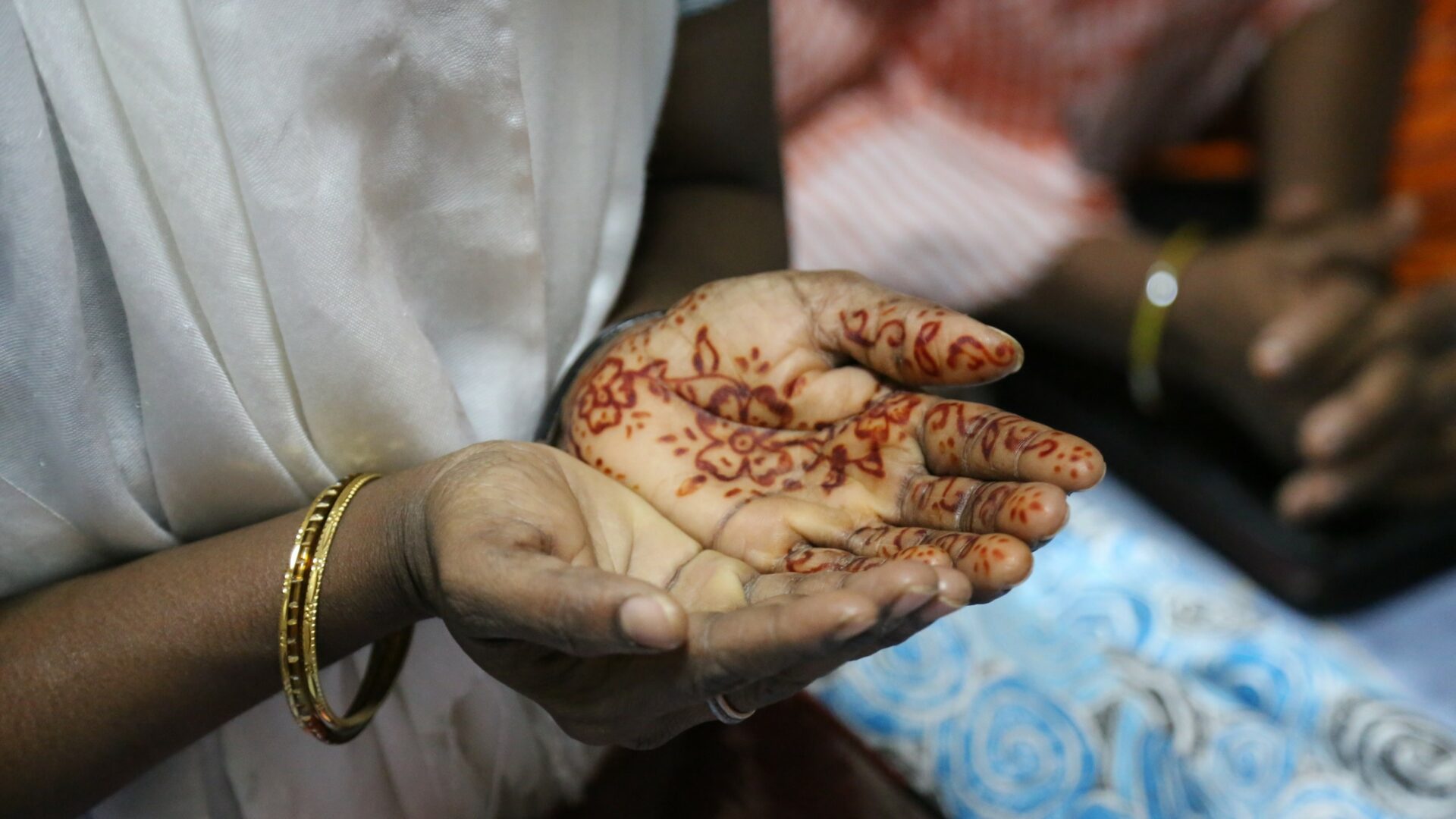 Intialaiset rukoilevan naisen kädet koristeltu hennatatuoinneilla