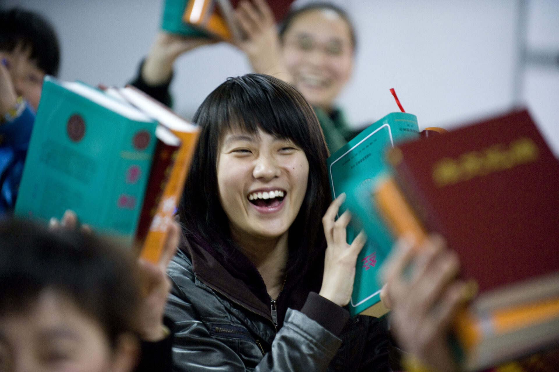 nainen nauraa ja pitelee Raamattua