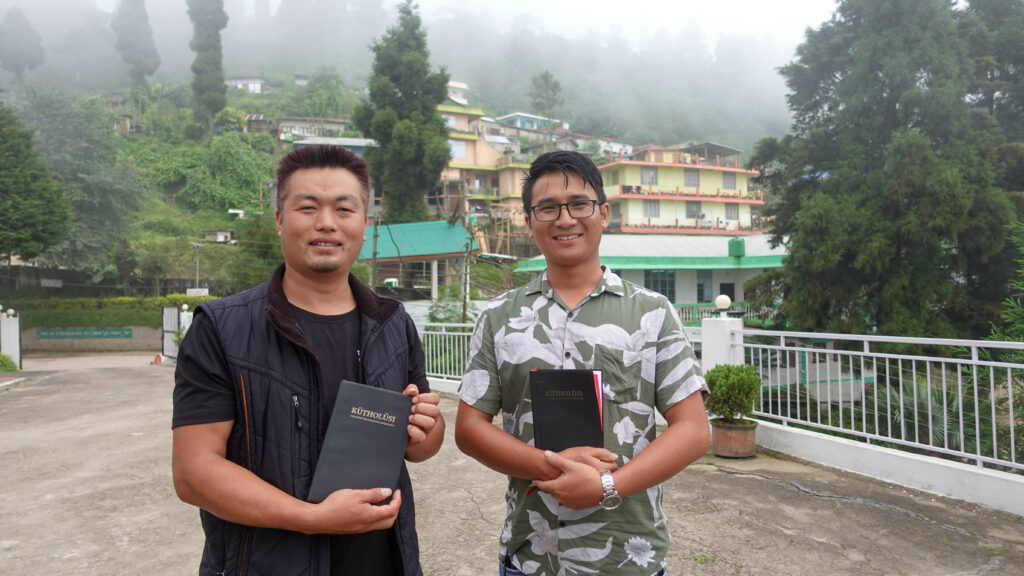 Kaksi miestä kädessään Raamattu