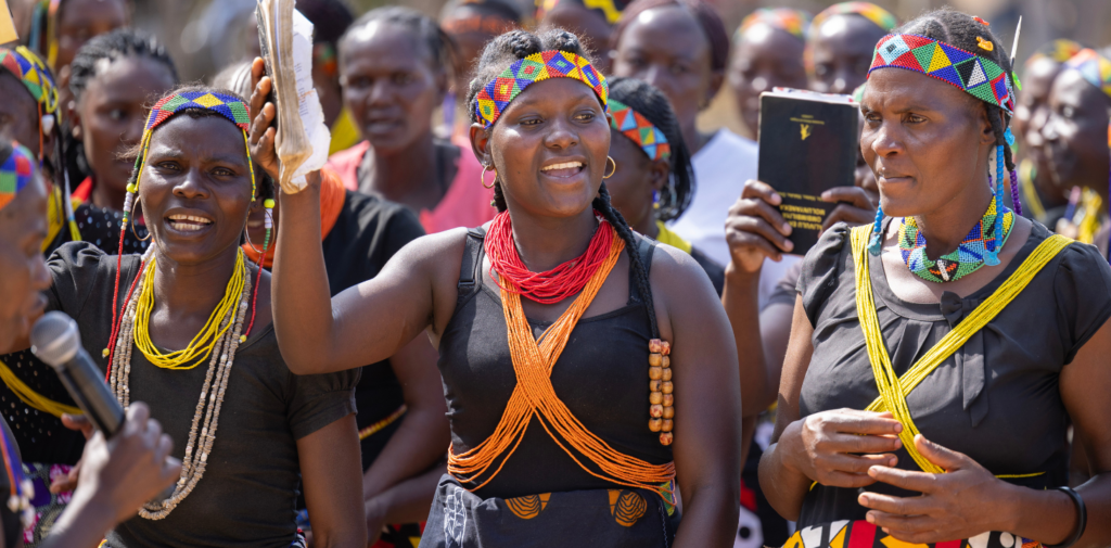 Angolalaiset naiset tanssivat ja laulavat Raamattu kädessä