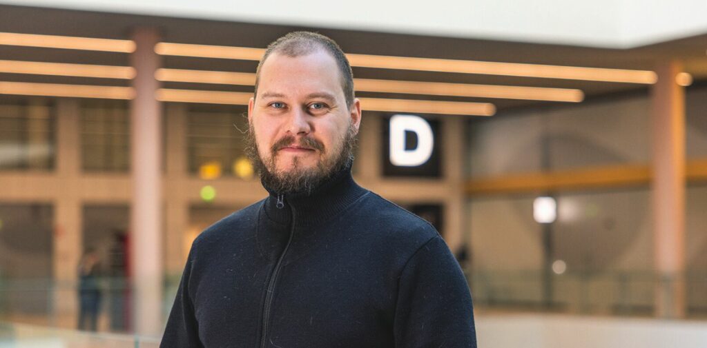 Mies kauppakeskuksessa katsoo kameraan