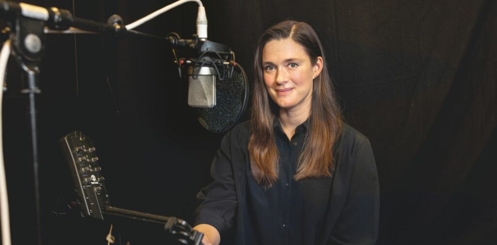 Nainen studiossa katsoo suoraan kameraan