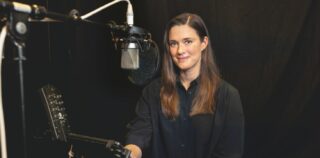 Nainen studiossa katsoo suoraan kameraan