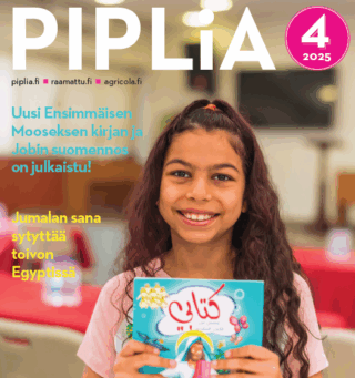 Tyttö pitää käsissään lastenraamattua ja hymyilee