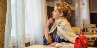 Nainen katsoo ikkunasta ulos