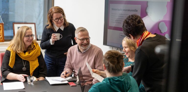 joukko ihmisiä nauramassa toimistolla