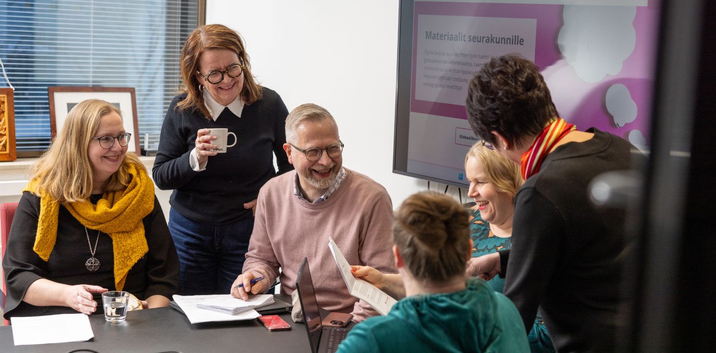 joukko ihmisiä nauramassa toimistolla