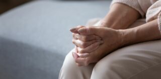 Kädet asetettu ristiin syliin