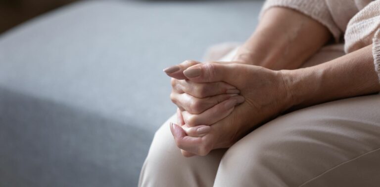 Kädet asetettu ristiin syliin