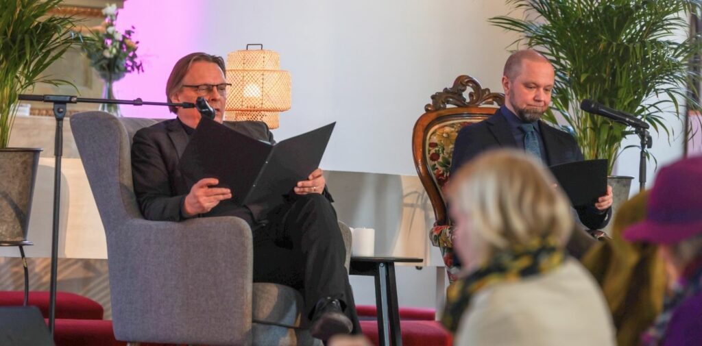 Kaksi miestä istumassa nojatuolissa kirkossa