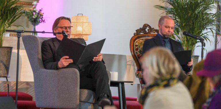 Kaksi miestä istumassa nojatuolissa kirkossa