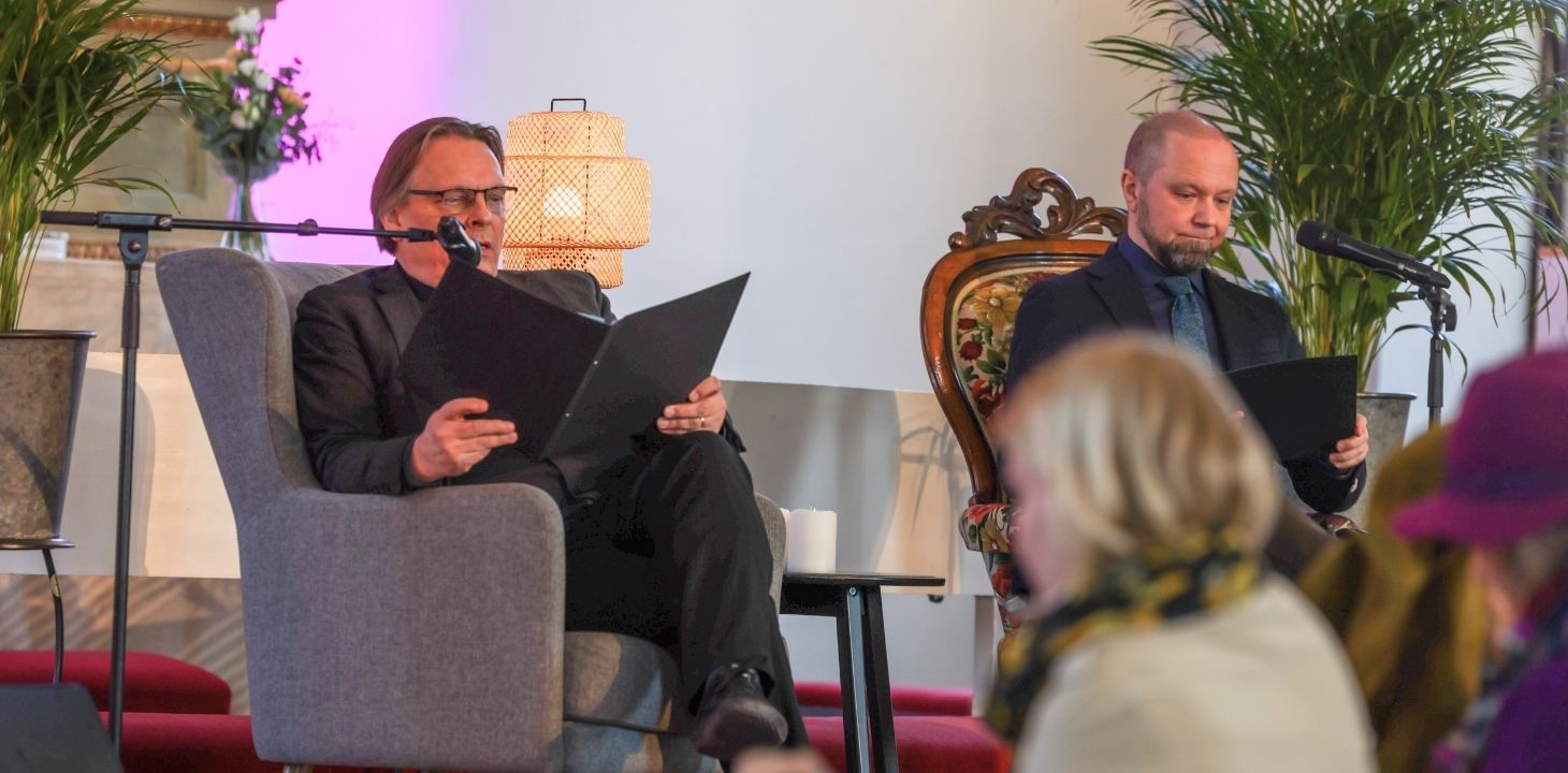 Kaksi miestä istumassa nojatuolissa kirkossa